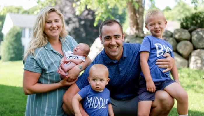 a family of five smiling outside