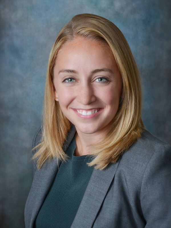 Headshot of Elisabeth Gilead, nurse practitioner at South Lake Pediatrics. Elisabeth has blonde hair, is wearing a grey blazer over a green top, and is smiling at the camera.