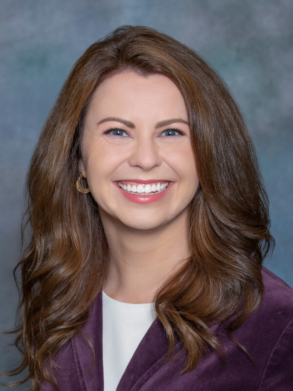 Headshot of Katherine Christopherson, nurse practitioner at South Lake Pediatrics. Katherine has brown hair, is wearing a purple blazer over a white top, and is smiling at the camera.