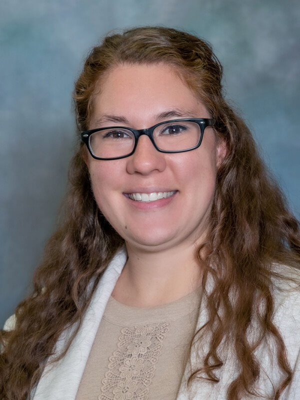 Headshot of Kristina Ihlang, nurse practitioner at South Lake Pediatrics. Kristina has long wavy hair, is wearing glasses and a light-colored top, and is smiling at the camera.