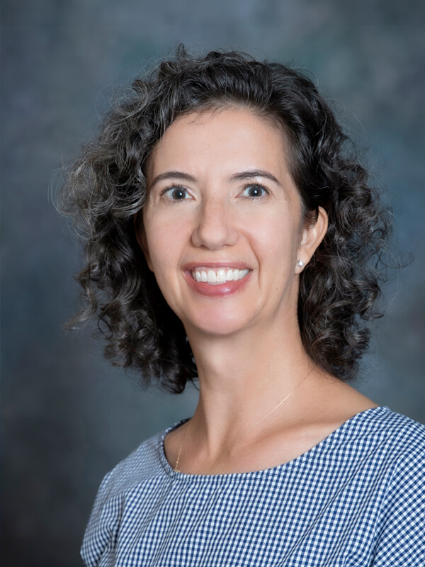 Headshot of Anne Skemp, pediatrician at South Lake Pediatrics. Anne has curly brown hair, is wearing a patterned top, and is smiling at the camera.