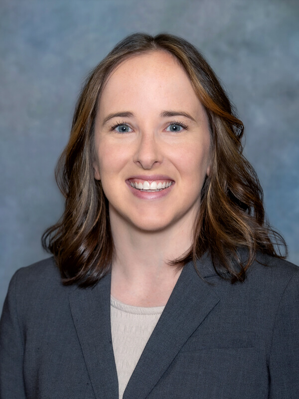 Headshot of Mary Meehan, pediatrician at South Lake Pediatrics. Mary has long brown hair, is wearing a dark blue top, and is smiling at the camera.